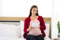 Pregnant woman sitting on bed and looking at her ultrasound image of her child in her belly Royalty Free Stock Photo