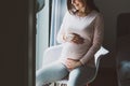 Pregnant woman sitting on chair at home Royalty Free Stock Photo