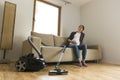 Pregnant woman sitting on couch tired of vacuuming. Household and spring cleaning concept Royalty Free Stock Photo