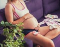 pregnant woman sitting on the couch and touching her belly at home. waiting for the newborn. Royalty Free Stock Photo