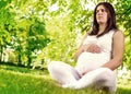 Pregnant woman sitting on grass