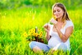 Pregnant woman sitting on green field Royalty Free Stock Photo