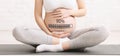 Pregnant woman sitting in lotus pose on yoga mat and touching her belly, collage with ninety percent loading bar Royalty Free Stock Photo