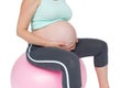 Pregnant woman sitting on pink exercise ball