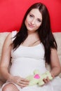 Pregnant woman sitting on sofa holding teddy bear Royalty Free Stock Photo