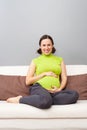 Pregnant woman sitting on sofa at home Royalty Free Stock Photo