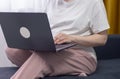 A pregnant woman is sitting on a sofa at home with a laptop. Communication by video link with the doctor with relatives. Royalty Free Stock Photo