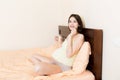 Pregnant woman is sitting in sofa. Taking pills from colds. Last months of pregnancy Royalty Free Stock Photo