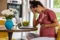 Pregnant woman feeling nauseous in front of laptop