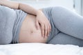 Pregnant woman sleeping in bed at home. Close up of pregnant woman lying in bed and touching her belly. Royalty Free Stock Photo