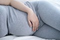 Pregnant woman sleeping in bed at home. Close up of pregnant woman lying in bed and touching her belly. Royalty Free Stock Photo