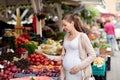 Pregnant woman with smartphone at street market Royalty Free Stock Photo