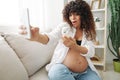 Pregnant woman smile blogger cream for pregnant women stretch marks body during pregnancy filming herself on phone Royalty Free Stock Photo