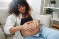 Pregnant woman smile and happiness lies on the couch freedom and strokes her belly with a baby in the last month of Royalty Free Stock Photo