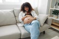 Pregnant woman smile and happiness lies on the couch freedom and strokes her belly with a baby in the last month of Royalty Free Stock Photo