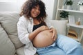 Pregnant woman smile and happiness lies on the couch freedom and strokes her belly with a baby in the last month of Royalty Free Stock Photo