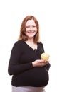 Pregnant woman smiling to the camera while holding an apple in her hands Royalty Free Stock Photo