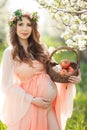 A pregnant woman in a spring garden with basket Royalty Free Stock Photo