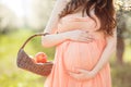 A pregnant woman in a spring garden with basket Royalty Free Stock Photo