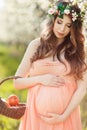 A pregnant woman in a spring garden with basket Royalty Free Stock Photo