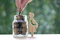 Pregnant woman with stack of coins money in glass bottle on natural green background,Save money for prepare in future and newborn Royalty Free Stock Photo