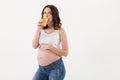 Pregnant woman standing isolated drinking juice