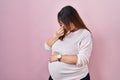 Pregnant woman standing over pink background tired rubbing nose and eyes feeling fatigue and headache Royalty Free Stock Photo