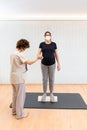 pregnant woman standing on a proprioceptive trunk for lumboabdominal and perineal walls with physiotherapist