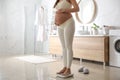 Pregnant woman standing on scales in bathroom, closeup Royalty Free Stock Photo