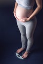 Pregnant woman standing on scales. Concept of weight loss and control during pregnancy Royalty Free Stock Photo