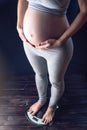 Pregnant woman standing on scales. Concept of weight loss and control during pregnancy Royalty Free Stock Photo