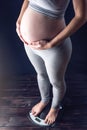 Pregnant woman standing on scales. Concept of weight loss and control during pregnancy Royalty Free Stock Photo