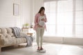 Pregnant woman standing on scales at home Royalty Free Stock Photo