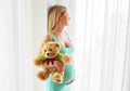 Pregnant woman standing with teddy bear Royalty Free Stock Photo