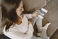 Pregnant woman stands by window and looks at photo