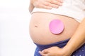 Pregnant woman with sticker on bump