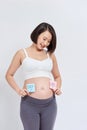 Pregnant woman with a sticky note and writing love boy or girl on sticky note and add on her belly Royalty Free Stock Photo