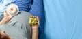 Pregnant woman with a stomach and holding donut and yellow measuring tape. Diet for pregnant women. Copy space for text.