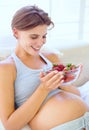 Pregnant woman, strawberry and nutrition in bedroom with relax wellness for eating fruit in house. Young person, happy Royalty Free Stock Photo