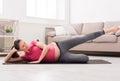 Pregnant woman stretching legs training indoors Royalty Free Stock Photo