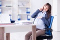 The pregnant woman struggling to do work in office Royalty Free Stock Photo