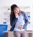 Pregnant woman struggling to do work in office Royalty Free Stock Photo