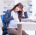 Pregnant woman struggling to do work in office Royalty Free Stock Photo