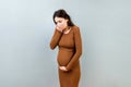 Pregnant woman suffering from toxicosis. Toxicosis Of Pregnancy. Pregnant Lady Feeling Sick Having Nausea Standing On Royalty Free Stock Photo
