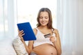 Pregnant woman with tablet pc and credit card Royalty Free Stock Photo