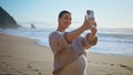 Pregnant woman taking photo seascape on smartphone close up. Future mother coast Royalty Free Stock Photo