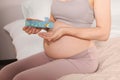 Pregnant woman taking pills on bed, closeup Royalty Free Stock Photo