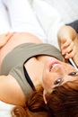 Pregnant woman talking mobile phone on sofa Royalty Free Stock Photo