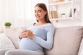 Pregnant Woman Texting On Cellphone Sitting On Sofa At Home Royalty Free Stock Photo