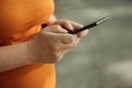 Pregnant woman texting outdoors Royalty Free Stock Photo